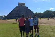 A group of visitors in front of the Kukulcan Pyramid with a local guide
